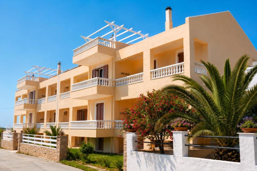 a large white building with palm trees in front of it at Marialena hotel in Archangelos