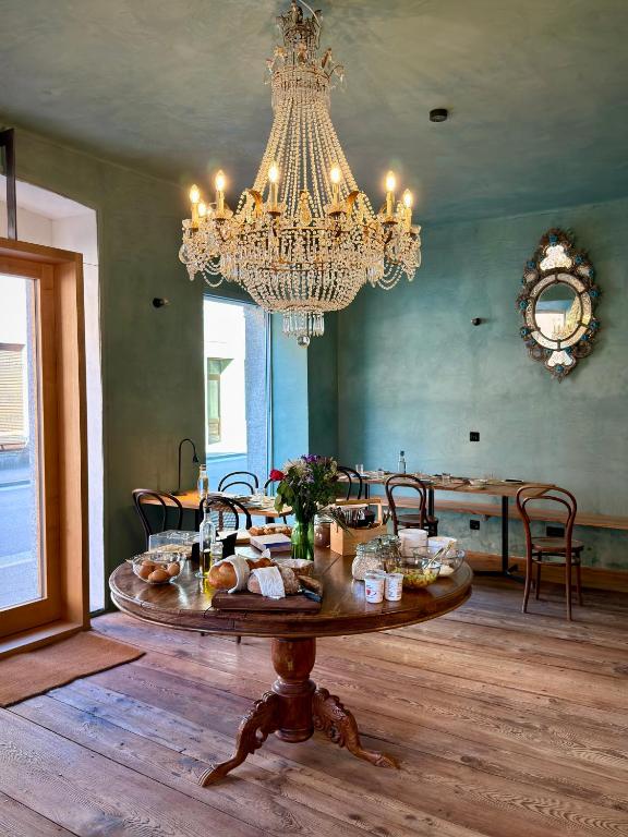 a dining room with a table with food and a chandelier at Casa Piumogna in Faido