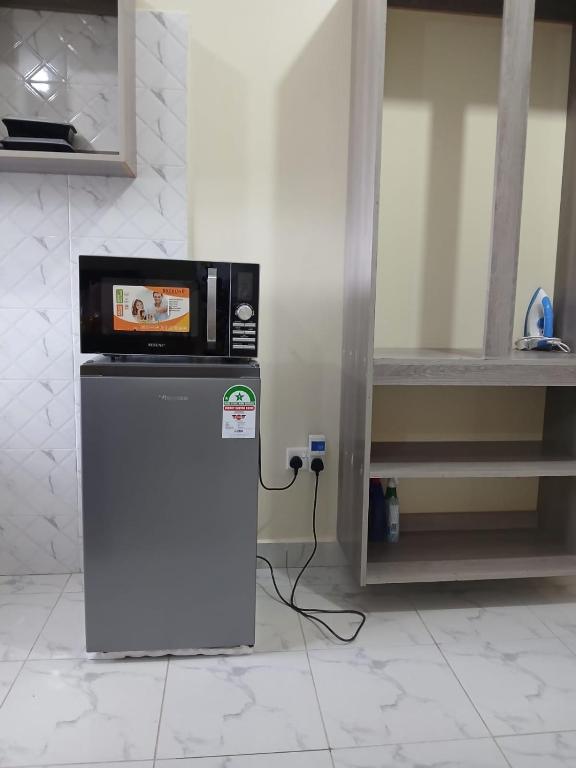 a microwave sitting on top of a refrigerator in a kitchen at Mbeyustays in Malindi