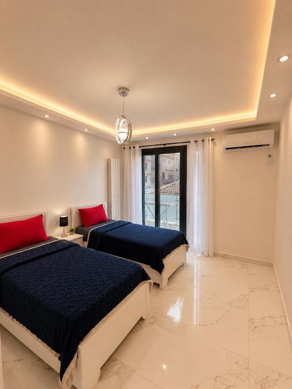 a bedroom with two beds and a large window at Resedece Ihssene in Kolea