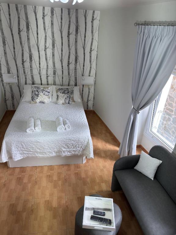 a small bedroom with a bed and a couch at Apartamento Linde in Muros