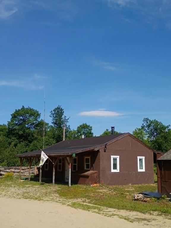 a house that is next to a dirt road at Nezinscot Pines in Hartford