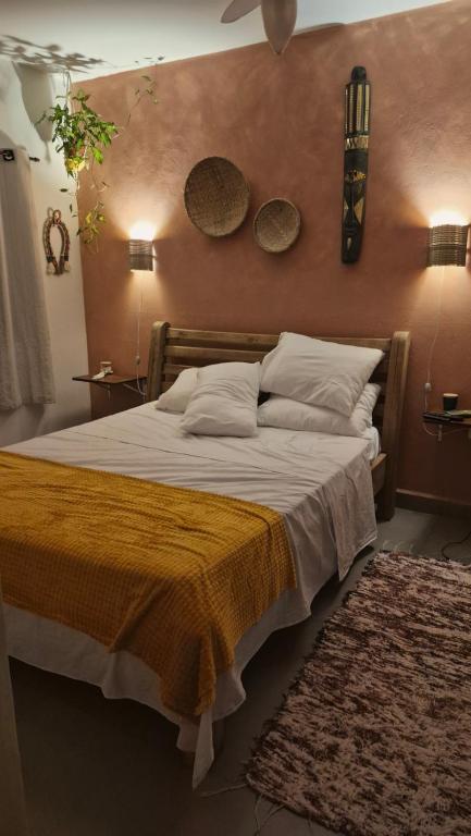 a bedroom with a bed and two mirrors on the wall at Morada Palmeira Real Peruibe - SP in Peruíbe