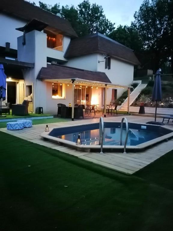 a swimming pool in front of a house at LAPAUSEDEGOUT piscine chambres climatisées terrasse table d'hôtes in Lachapelle-Auzac