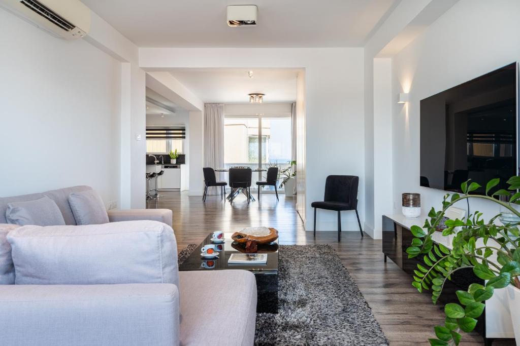a living room with a white couch and a table at Luxury 2BR Limassol Marina Views in Limassol