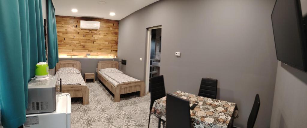 a room with two chairs and a room with a bed and a television at Podlovics Tanya Panzió in Kemecse