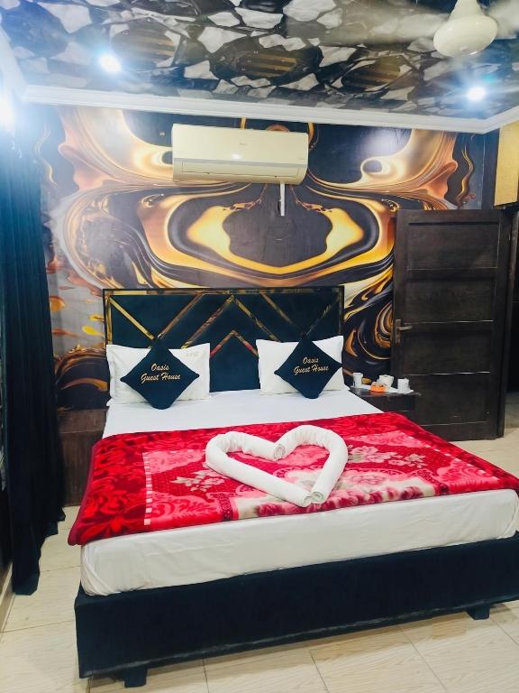 a bedroom with a bed with two white hearts on it at Crown Valley Guest House in Lahore