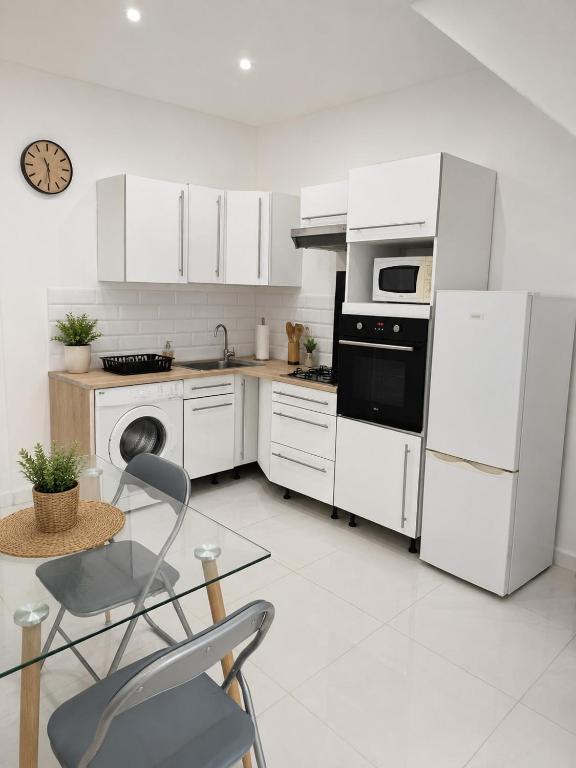 a kitchen with white appliances and a table and a chair at Slimmo Studio in Château-Chinon