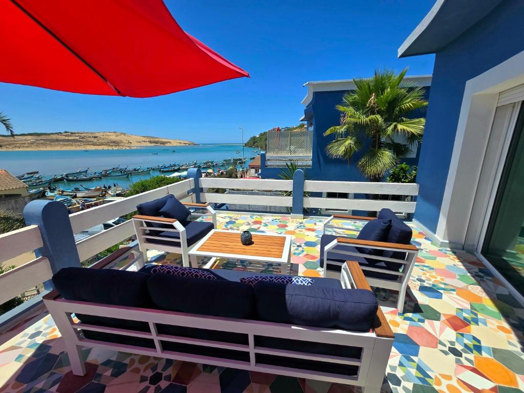 a patio with chairs and a table and an umbrella at lagoon apartment 3 in Moulay Bousselham