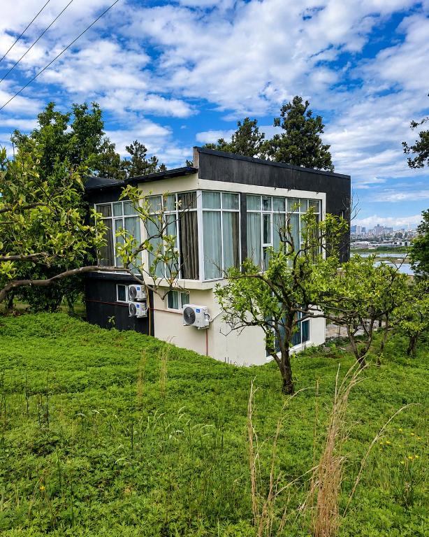 a house sitting on top of a grassy hill at Hillside House Overlooking Batumi in Charnali