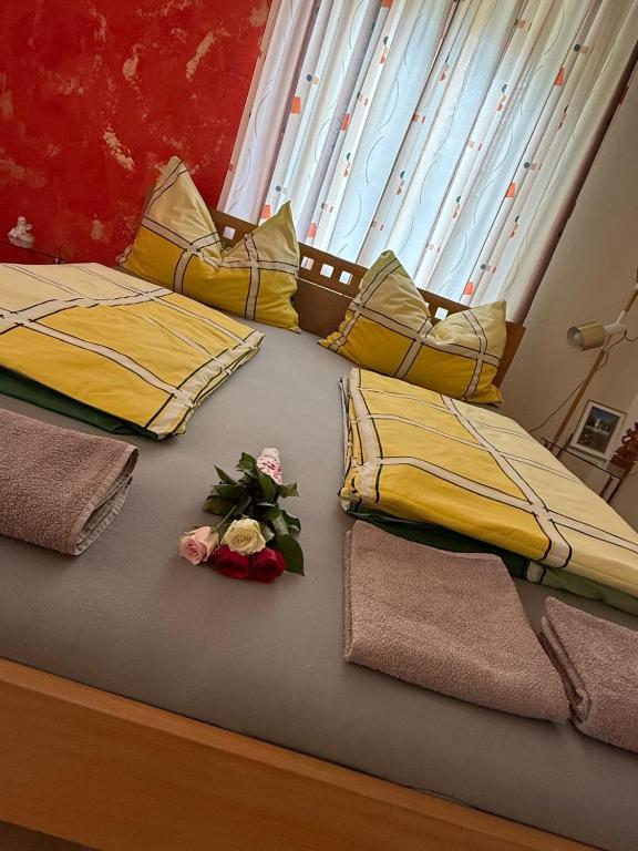 a bed with two roses and two towels on it at Haus Brenntara 1 in Rangersdorf