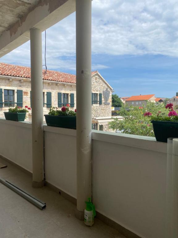 a balcony with columns and flowers on a building at Campanella Old Town by Mrav in Sukošan