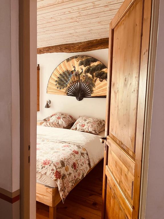 a bedroom with a bed and a wooden door at A L’Abri Du Loup in Roquefort-sur-Garonne
