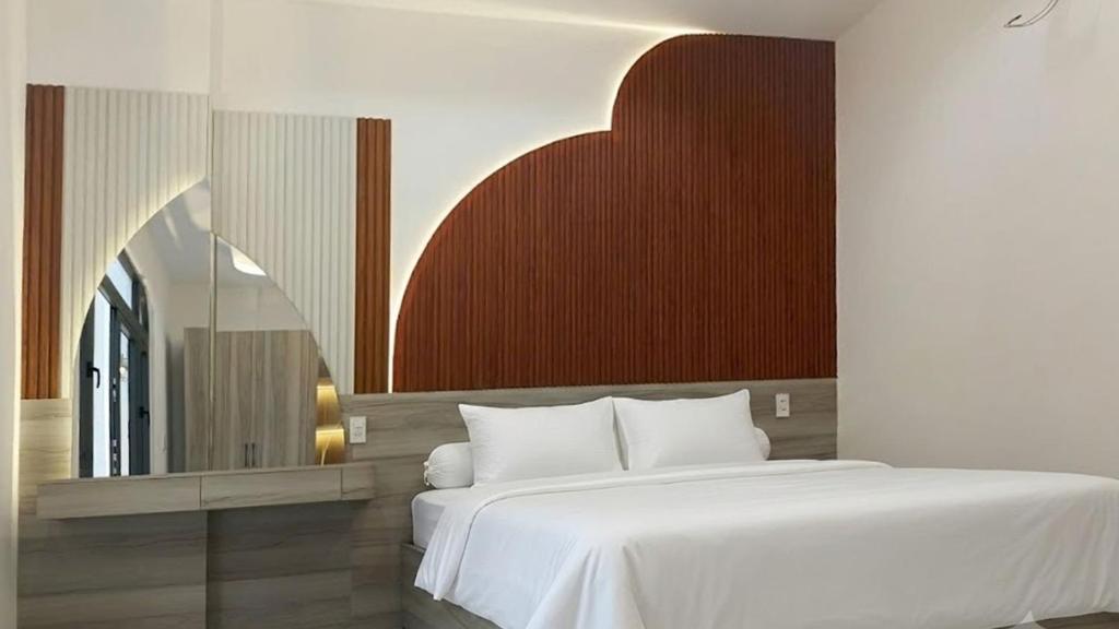 a bedroom with a white bed and a red wall at Mai Song Linh in Phan Rang–Tháp Chàm