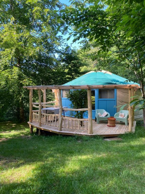 a gazebo with a blue umbrella on a deck at Les Jardins d'Yzorche in Saint-Bazile-de-la-Roche
