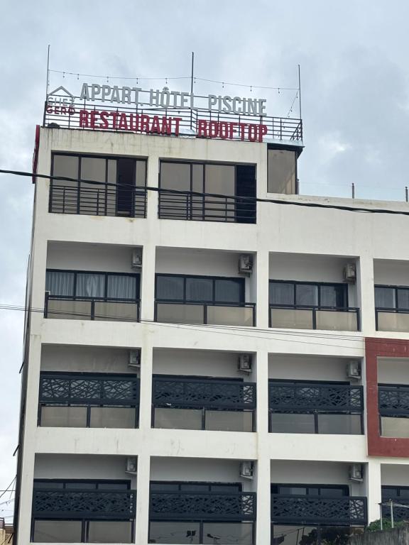an apartment building with a sign on top of it at Chez Gero Aeroport in Cotonou