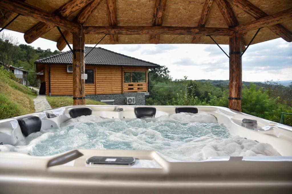 a hot tub in a gazebo in front of a house at Boja zalaska - drveni apartman in Jagodina