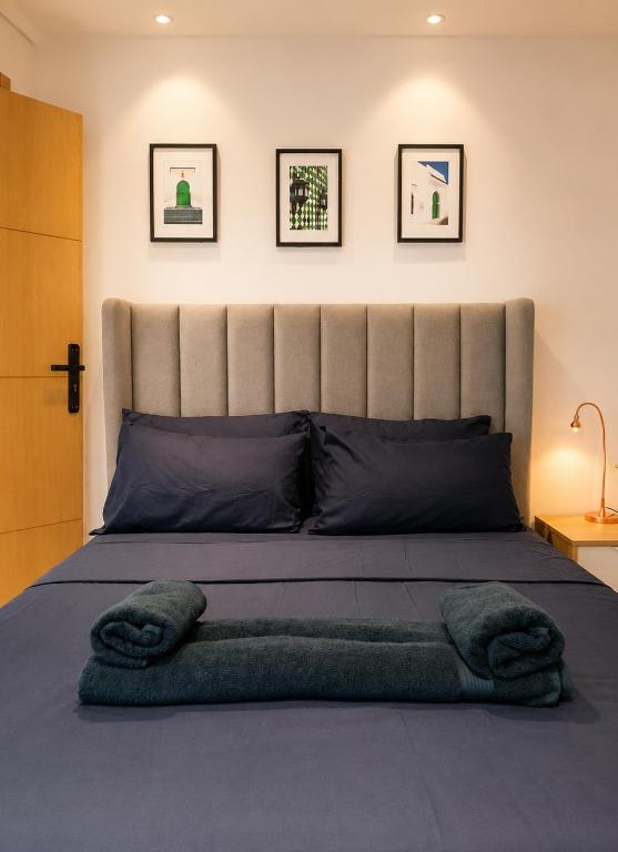 a bedroom with a large bed with a large headboard at Studio Chic avec Terrasse Verdoyante in Casablanca