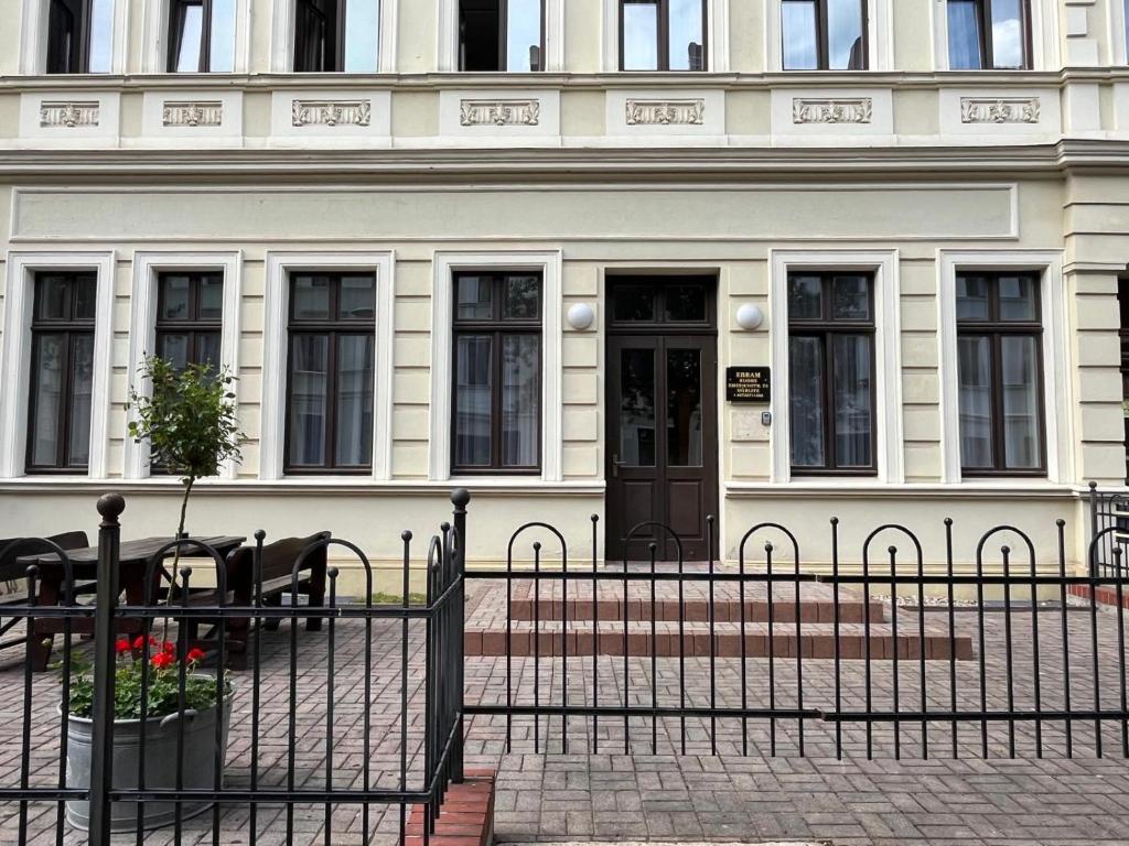 a white building with a black door and a table at Ebram Apartments Görlitz in Görlitz