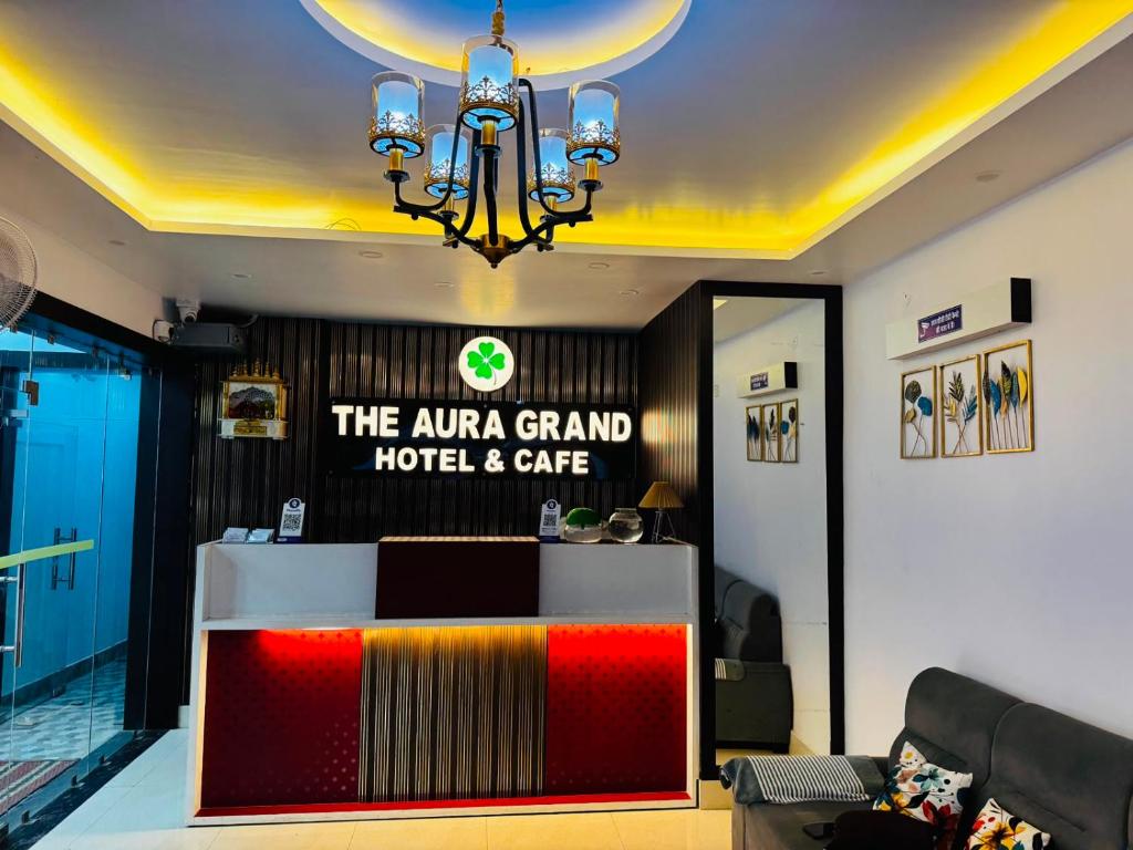 a hotel lobby with a reception desk and a chandelier at The Aura Grand Hotel and Cafe in Patna