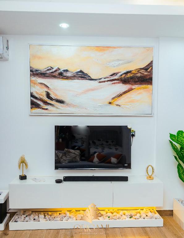 a living room with a flat screen tv on a wall at ORIGAMI APARTMENTs in Boi