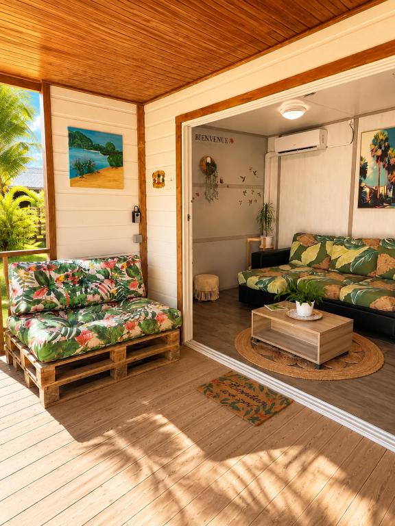 a screened in porch with a couch at Au Paradis de Peggy - Bungalow 5 pers - Village de la Pointe Faula in Le Vauclin