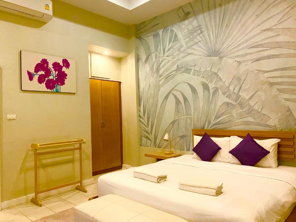 a bedroom with a large bed with purple pillows at Spice & Sea Resort in Kata Beach
