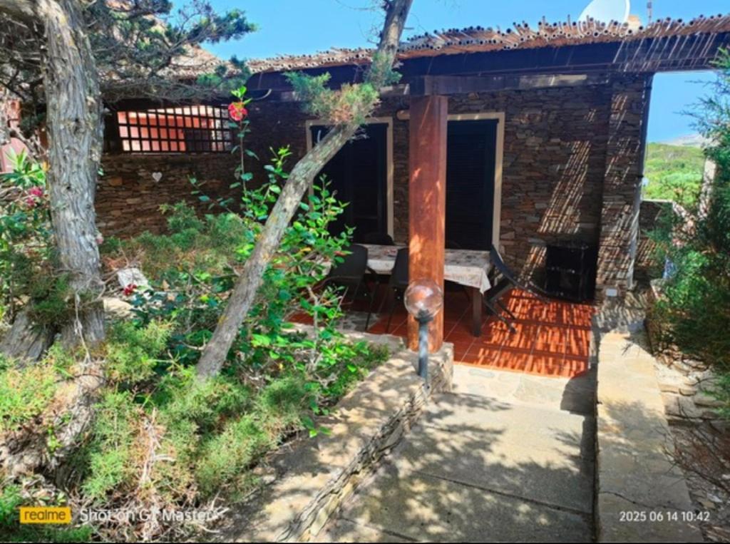 a stone house with a porch and a patio at Villa Clelia in Stintino