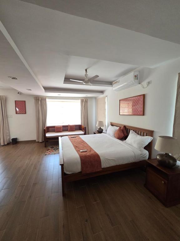 a bedroom with a large bed and a couch at Aqua blue bay villa in Covelong