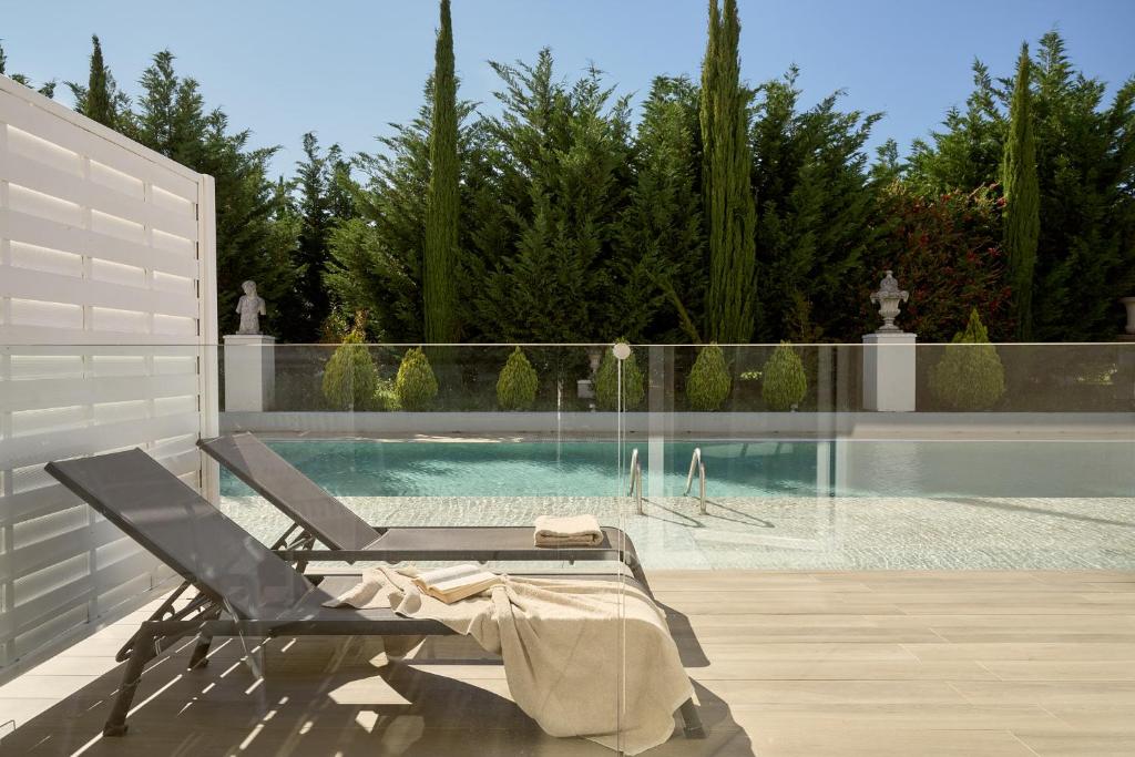 a swimming pool with a lounge chair next to a swimming pool at Sandy Villas Resort by Rizos Resorts in Línia