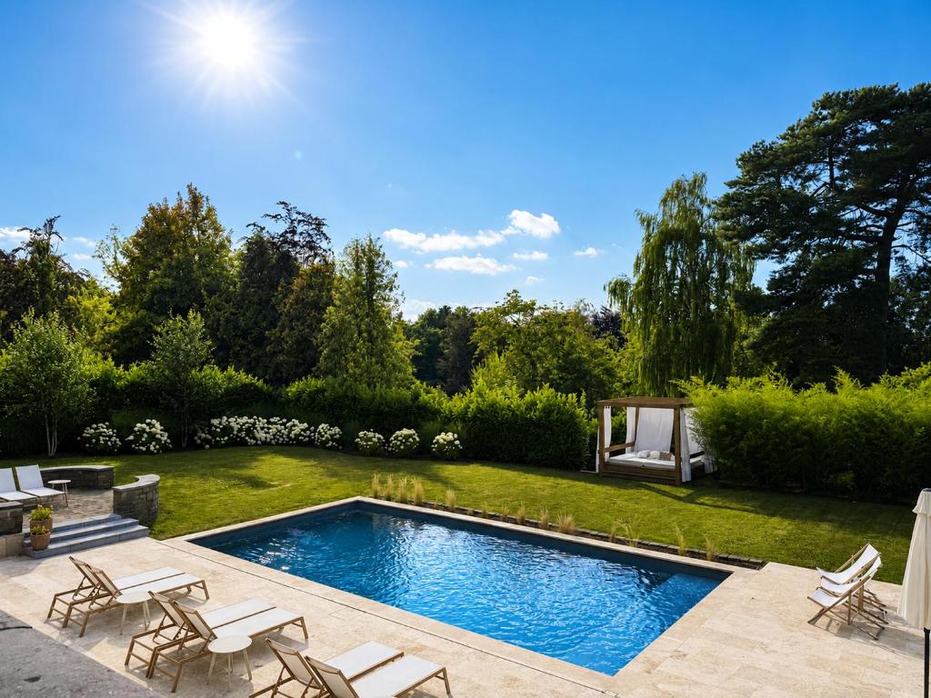 a swimming pool in a backyard with chairs and a lawn at Héritage Collection - Suites in Verviers