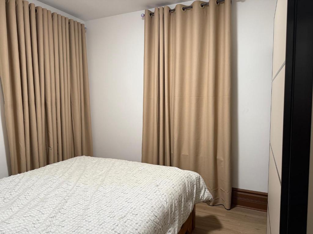 a bedroom with a bed and curtains in it at Downtown Residance Room 2 in Guelph