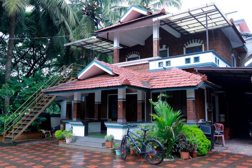 a house with a bicycle parked in front of it at Nirmalyam Homestay in Kuttippuram