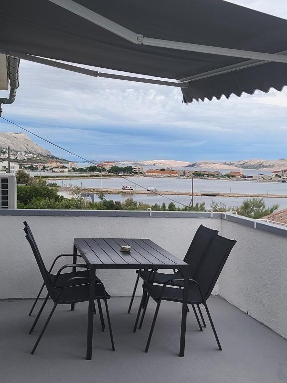a table and two chairs on a balcony with a view at Aparmani Đani 2 in Pag