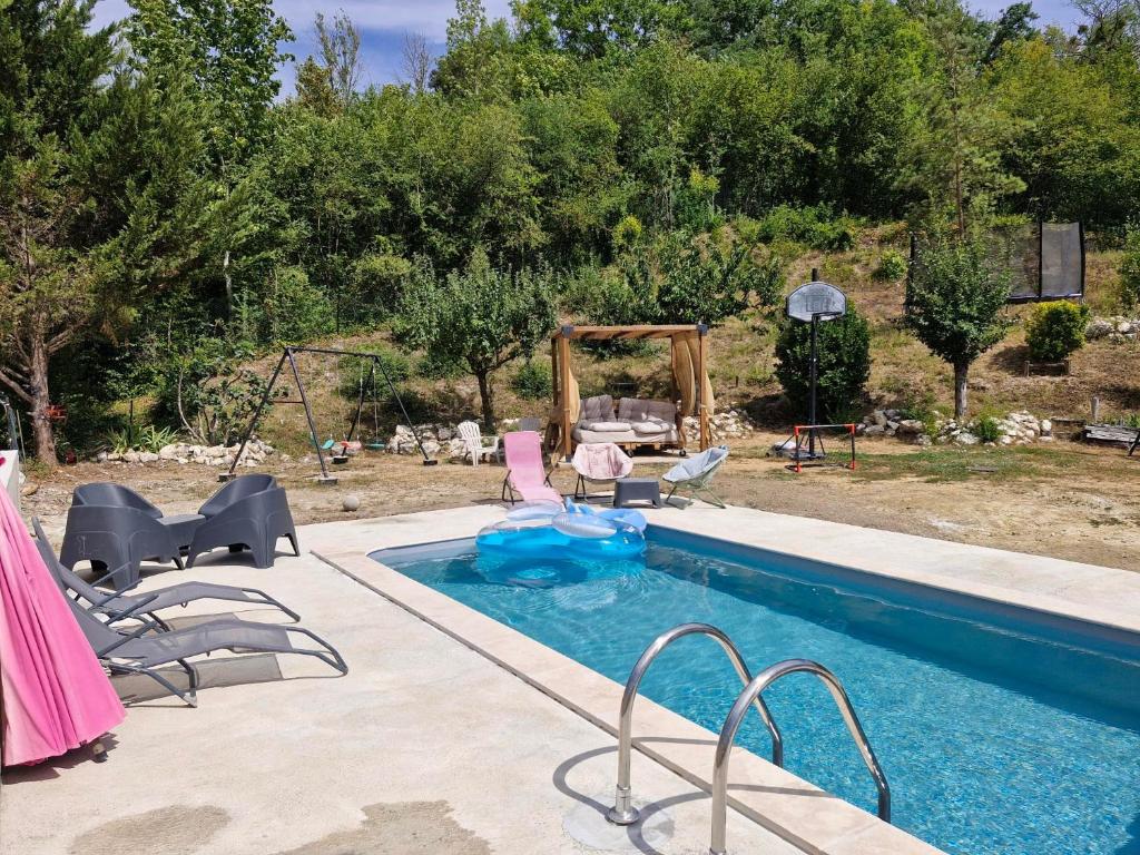 a swimming pool with chairs and a swing at Gite "D" dans une ancienne corps de ferme in Poigny