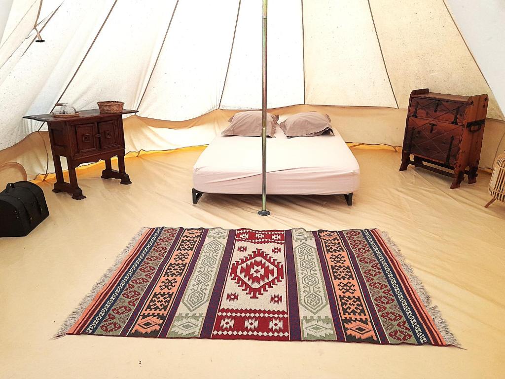 a bedroom with a tent with a bed and a table at Glamping en Tente Yourte in Ispagnac