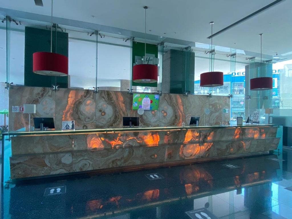 The reception desk sits behind glass walls and dramatic stone-patterned panels.