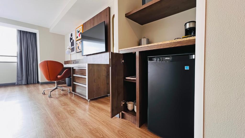 A compact in-room work area beside the television and minibar.