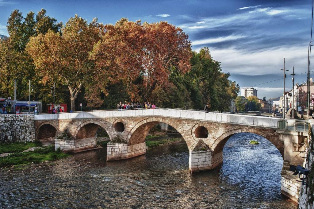 een brug over een rivier met mensen die erop lopen bij Apartment Latin Bridge in Sarajevo