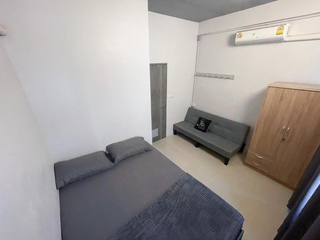 a room with a bed and a chair in it at Maxi mama House in Bangkok