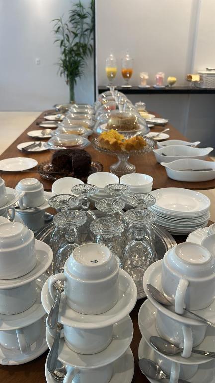 a long table with white plates and dishes on it at UMARI Reserva Hotel in Marituba