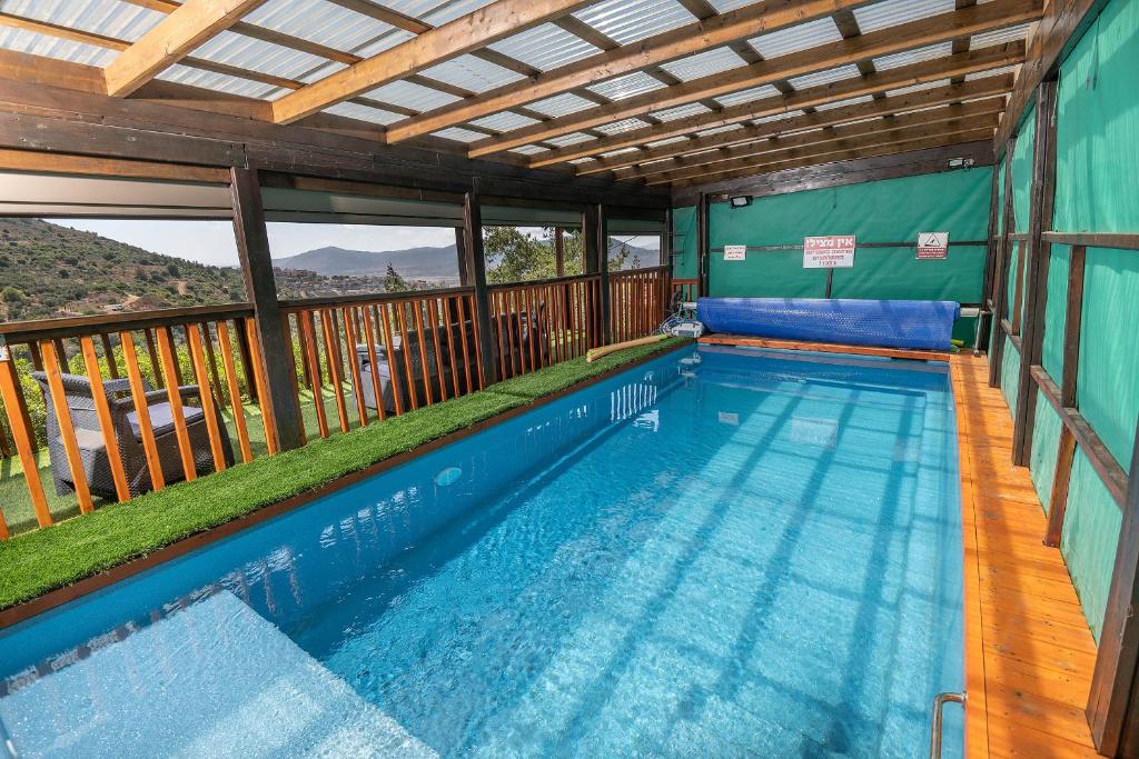 a swimming pool in a house with a deck at נוף ארץ הגליל - צימרים מהממים במצפה נטופה in Mitspe Netofa
