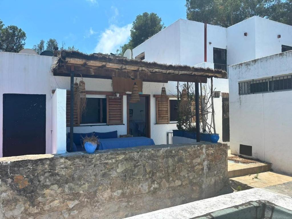 a house with a blue couch in front of a wall at Maison de plage Marsa M'diq 2 chambres et Salon in M'diq
