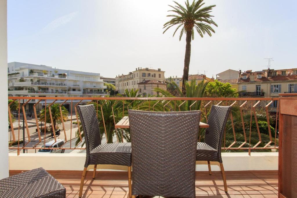 d'une terrasse avec 3 chaises et un palmier sur un balcon. dans l'établissement Maria Sea Cannes, à Cannes