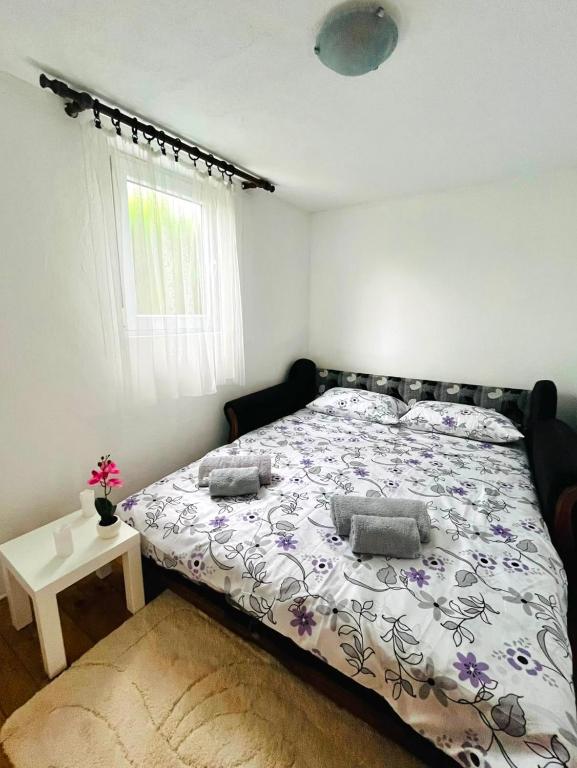 a bedroom with a bed with a floral bedspread at Casa Kraljevo in Kraljevo