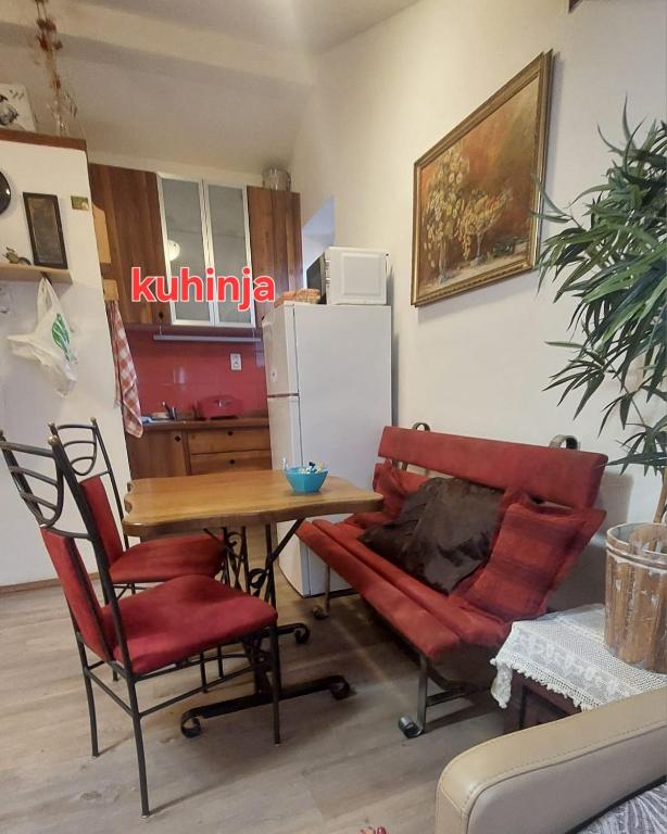 a kitchen with a table and chairs and a refrigerator at Eos in Piran