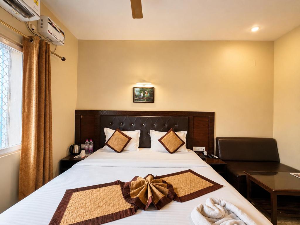 a bedroom with a bed with a bow on it at Hotel Puri Waves - Near Blue Flag Beach - Restautant, Parking & Spa in Puri