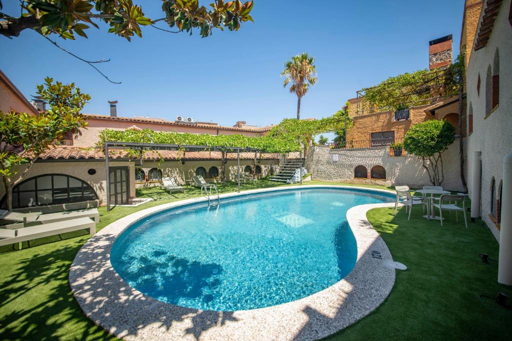 a swimming pool in a yard next to a building at Hotel La Grava in El Morell