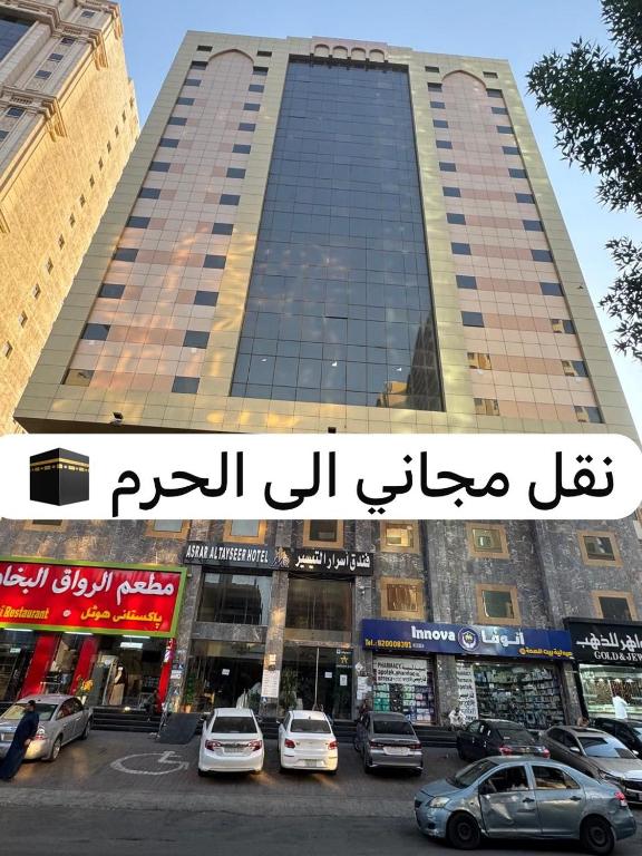 a large building with cars parked in front of it at فندق اسرار التيسير in Mecca