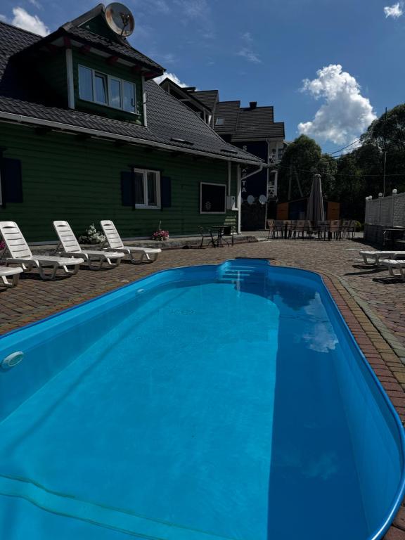 a blue swimming pool in front of a house at SKI Xata in Bukovel
